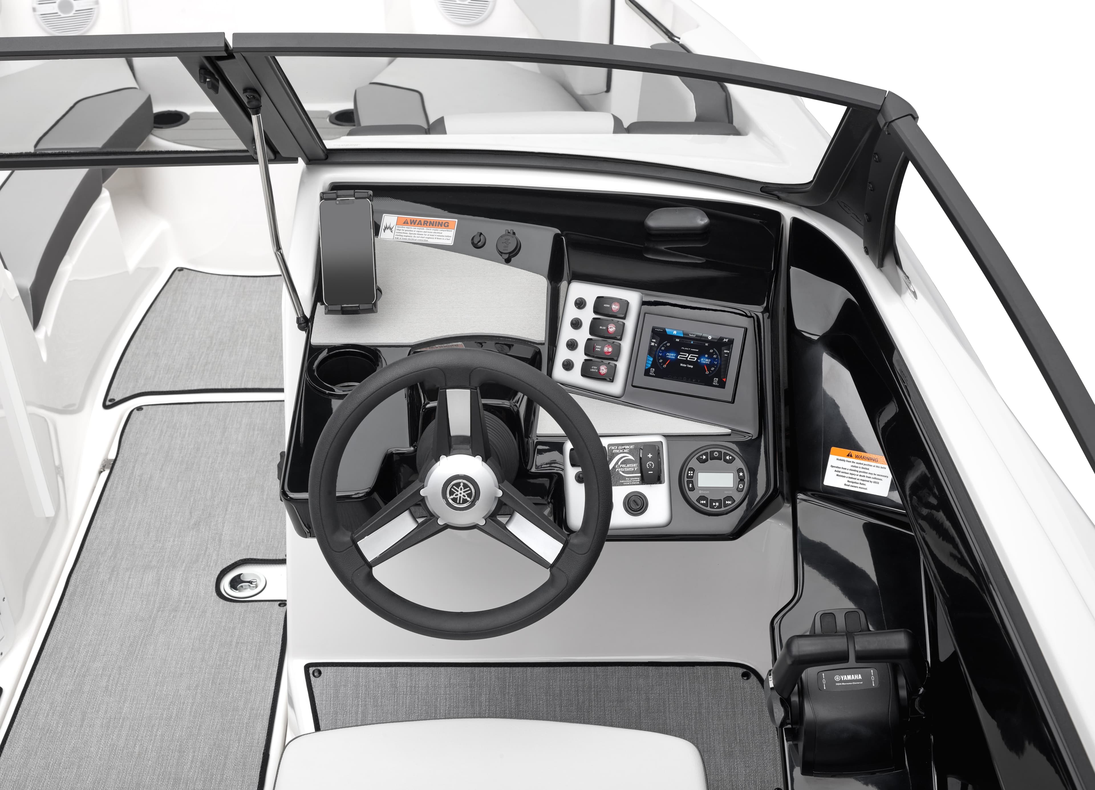 Interior view of wakeboard boat helm station with Yamaha steering wheel, dashboard controls, and white upholstery