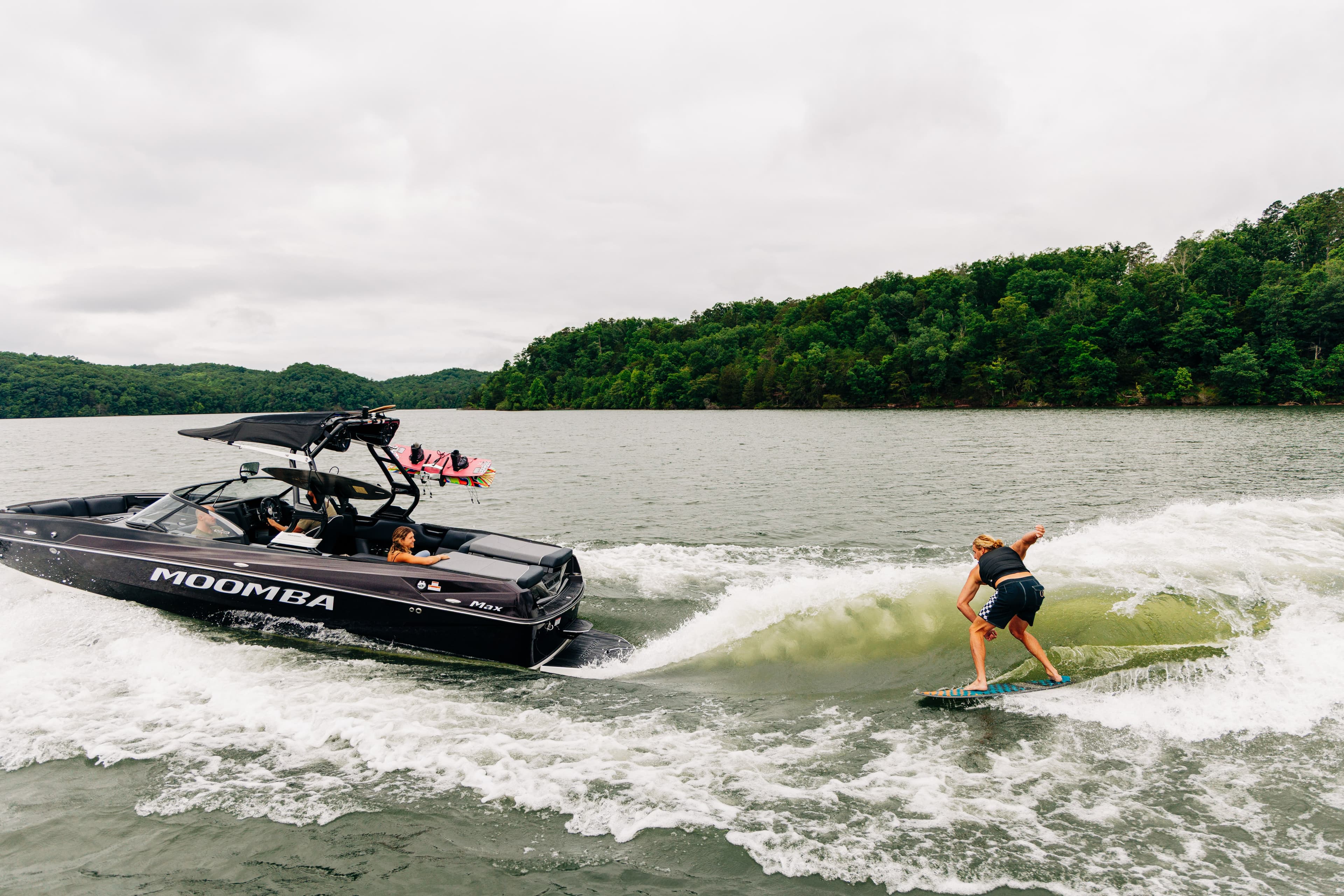 Black Moomba Max on the lake with a wake surfer riding behind it
