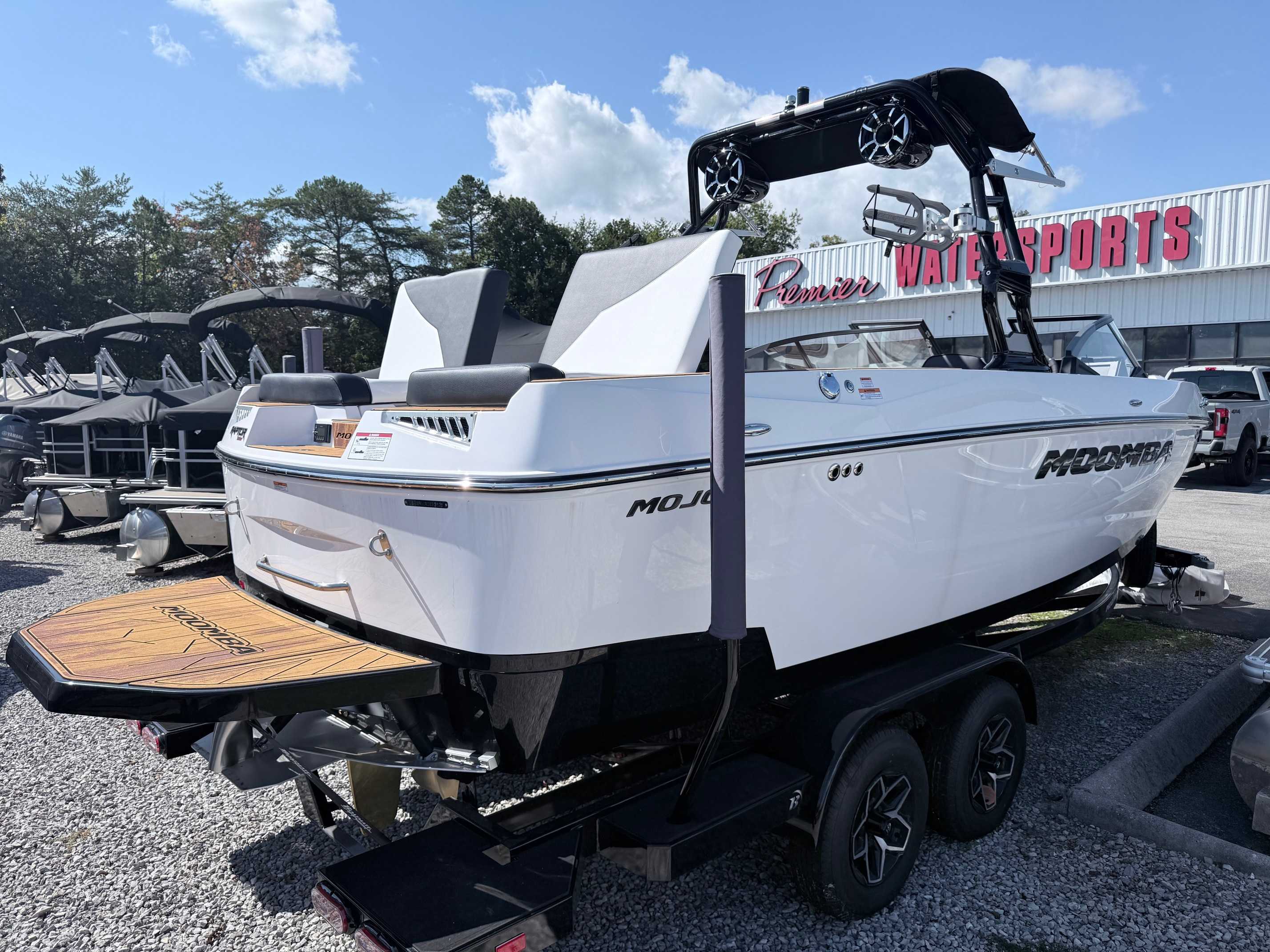 White Moomba Mojo wakeboard boat with black wake tower on display trailer at Premier Watersports dealership